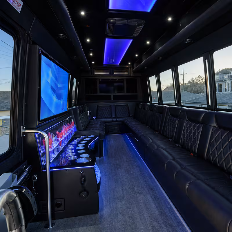 Party bus interior with wraparound leather seating and LED lighting in New Orleans