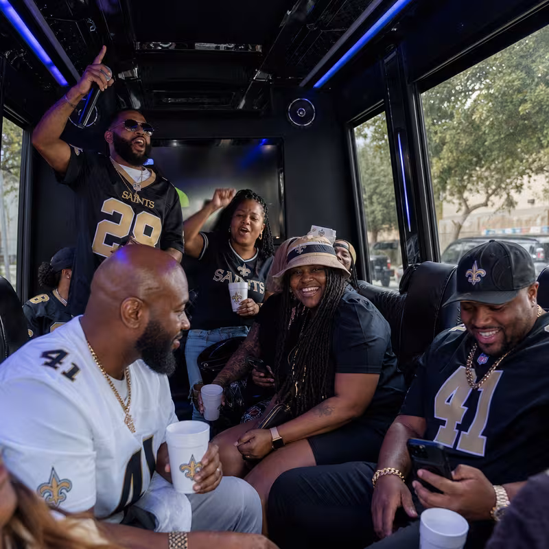 Group boarding a white charter bus for Sporting Event Transportation transportation in New Orleans